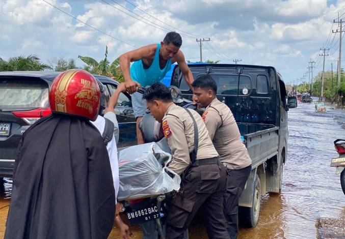 Aksi Polisi di Lokasi Banjir Pelalawan, Bantu Angkat Motor Warga Terjebak Mogok