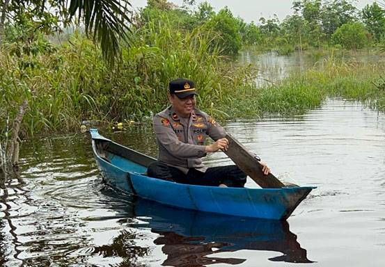 Naik Sampan, Kapolsek Kerumutan Sampaikan Pesan Kamtibmas Pemilu Damai ke Warga Terdampak Banjir