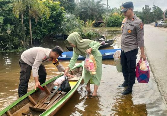 Polisi Bantu Warga dan Sampaikan Pesan Pemilu Damai di Lokasi Banjir Langgam