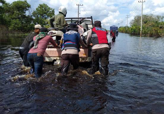 Polisi Berjibaku Bantu Warga Pangkalan Kuras di Lokasi Banjir Sembari Sampaikan Pesan Pemilu Damai 2024
