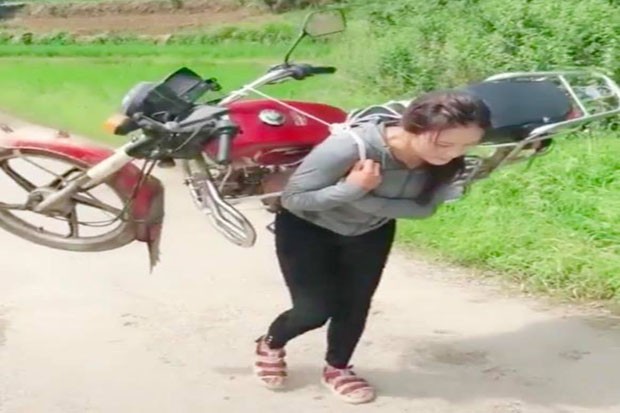 Mogok, Wanita Cantik Ini Gendong Sepeda Motor Menuju Rumah