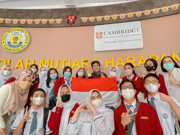 Frederick berfoto bersama dengan guru pembimbing olimpiade dan teman-temannya di Sekolah Mutiara Harapan.