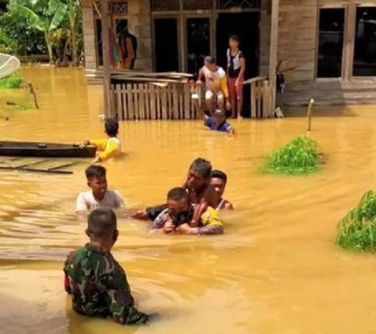 Anggota Bhabinkamtibmas Polsek Seberida Gendong Warga Lumpuh yang Terdampak Banjir