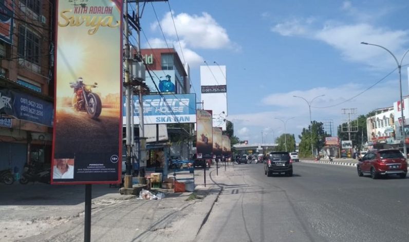 Iklan Rokok Berjejer di Jalan Tuanku Tambusai, Tiang Reklamenya di Atas Trotoar