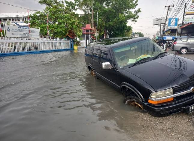 Tak Tahu Ada Lubang karena Banjir, Mobil Ini Terperosok ke Parit