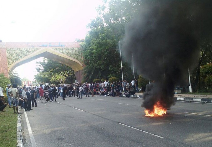 Massa yang Menolak Deklarasi #2019GantiPresiden Bakar Ban di Tengah Jalan Arah Bandara
