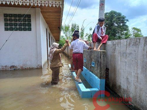 Sekolah Kebanjiran, Siswa di Pekanbaru Terpaksa Panjat Pagar Demi Persiapan UN