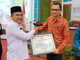 Wakil Bupati Pelalawan Nasaruddin menyerahkan penghargaan yang diterima langsung oleh Community Development (CD) Head RAPP F Leohansen Simatupang.