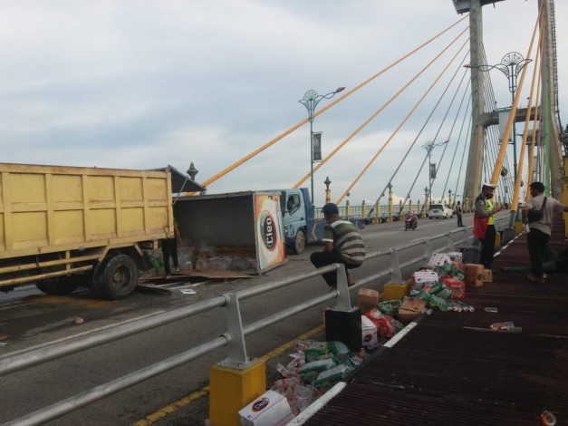 Truk Terguling di Jembatan TASL Siak, Puluhan Kardus Air Mineral Berserakan ke Jalan